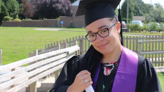 Female College student at her graduation proudly holding her certificate