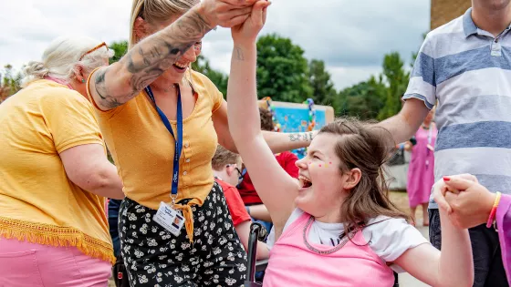 female student laughing in her wheelchair and dancing