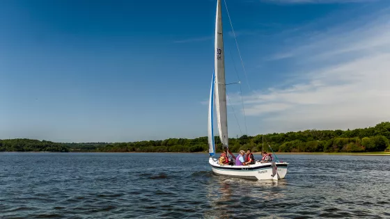 young students sailing on a lake on a sunny day