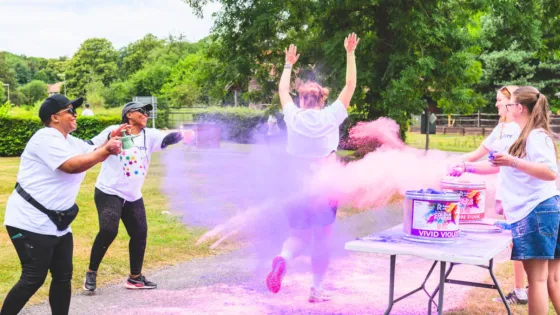 A runner passes through a paint station on a colour run.