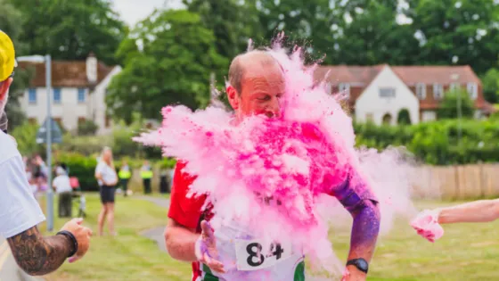 A cup of colourful paint is thrown on a runner at the 2026 StarRun.