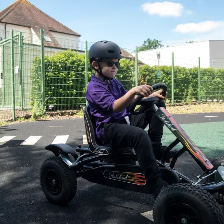 Male School student races in a go-kart 