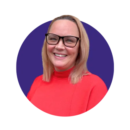 Short blonde haired woman smiling with glasses and a red top
