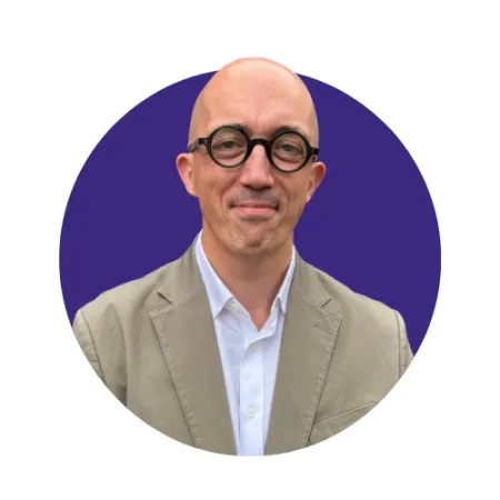 A man wears glasses and a suit.