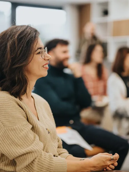 A group of adults sit in an audience of a training event. 